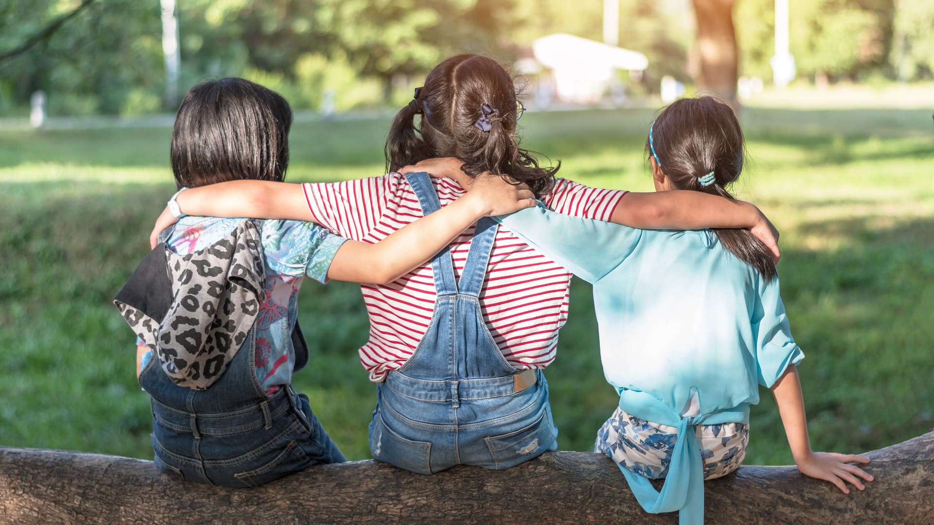 Kinder auf Baumstamm im Park